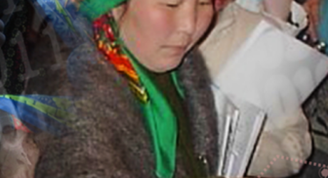 image of woman casting ballot with green headscarf