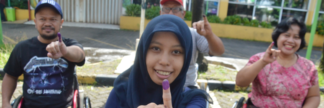 People showing their ink stained hands after voting. 