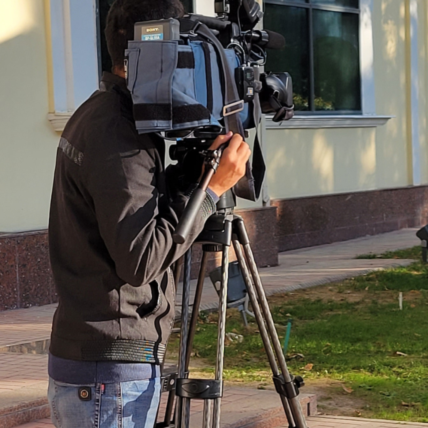 person operating camera  with reporter in Uzbekistan.